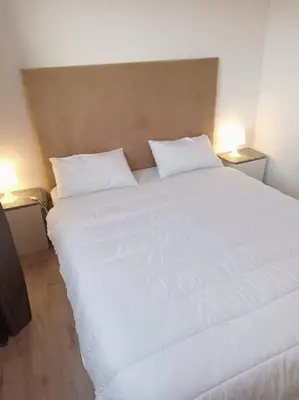 a large white bed in a room with two lamps at appartement de luxe marrakech in Marrakech