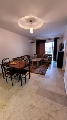 a living room with a table and a couch at Appartement 29 avec balcon pour famille in Marrakech