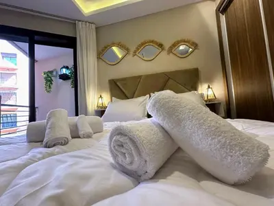 a bedroom with a large white bed with towels on it at Les marguerites avec piscine près du jardin majorelle in Marrakech