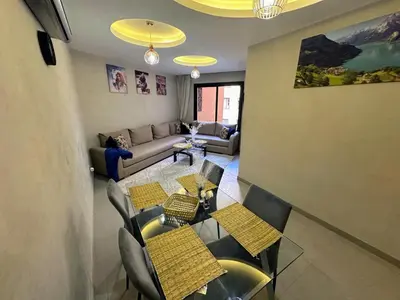 a living room with a table and chairs and a couch at Les marguerites avec piscine près du jardin majorelle in Marrakech