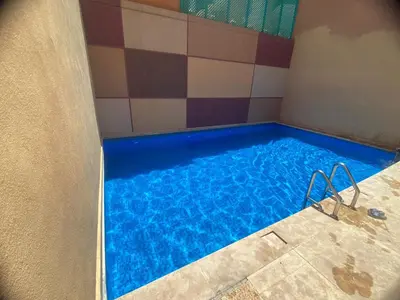 a swimming pool with blue water in a room at Les marguerites avec piscine près du jardin majorelle in Marrakech