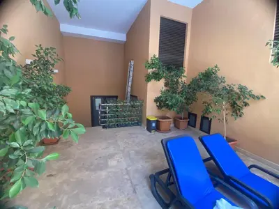 a room with two blue chairs and trees and a fireplace at Les marguerites avec piscine près du jardin majorelle in Marrakech