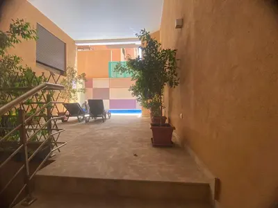 a hallway with stairs and potted plants in a building at Les marguerites avec piscine près du jardin majorelle in Marrakech