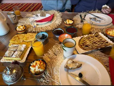 a table topped with plates of food and glasses of orange juice at Riad Almonds Marrakech in Marrakech