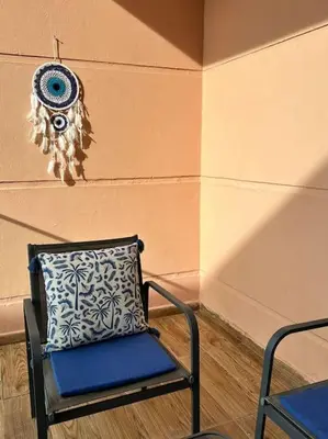 a blue chair with a pillow next to a wall at Appartement Cosy à Marrakech in Marrakech