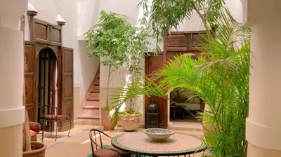 a room with a table and chairs and plants at Authentique riad Emplacement exceptionnel in Marrakech