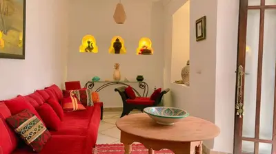 a living room with a red couch and a table at Authentique riad Emplacement exceptionnel in Marrakech