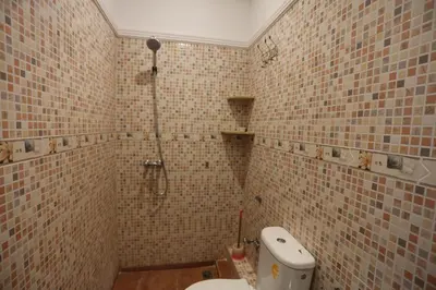 a tiled bathroom with a toilet and a shower at Villa Les Terrasses Des Jardins in Marrakech