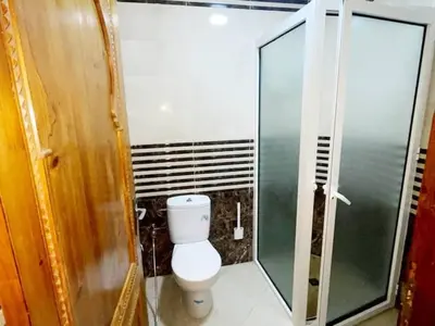 a bathroom with a toilet and a glass shower at Maison d'hôtes Marrakech in Marrakech