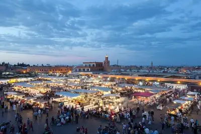 a crowd of people walking around a market at night at Maison d'hôtes Marrakech in Marrakech