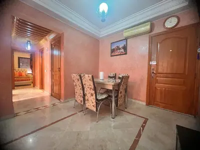 a dining room with a table and chairs and a clock at prestige andalouse 4 in Marrakech