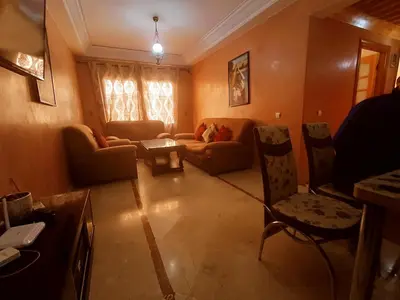 a living room with a couch and a table and chairs at prestige andalouse 4 in Marrakech