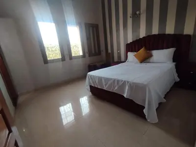 a bedroom with a bed and two windows at golf amelkis médina 1 N 50 in Marrakech