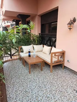 a couch and a coffee table on a patio at Somptueux appartement avec terrasse et piscines in Marrakech