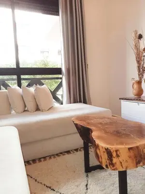 a living room with a white couch and a table at Somptueux appartement avec terrasse et piscines in Marrakech
