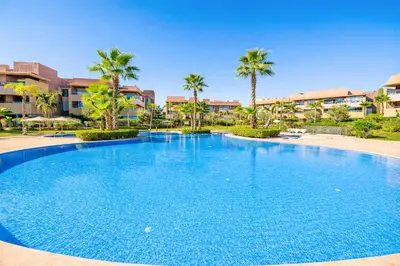 a large swimming pool with palm trees and buildings at Expérience luxueuse Golf Prestigia Saphir BY KECH in Marrakech