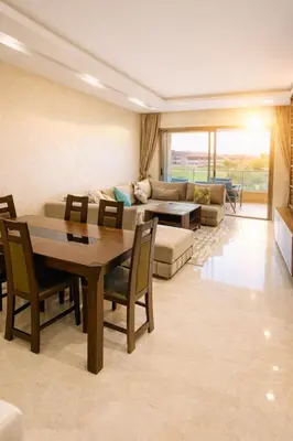 a living room with a table and a couch at Expérience luxueuse Golf Prestigia Saphir BY KECH in Marrakech