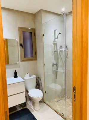 a bathroom with a toilet and a glass shower at Expérience luxueuse Golf Prestigia Saphir BY KECH in Marrakech
