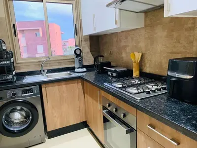 a kitchen with a stove top oven next to a sink at Expérience luxueuse Golf Prestigia Saphir BY KECH in Marrakech