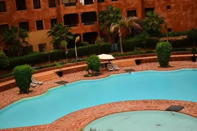 a large swimming pool in front of a building at Oasis aux Palmeraies à Marrakech in Marrakech