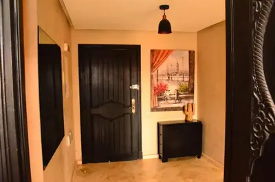 a hallway with a black door and a painting at Oasis aux Palmeraies à Marrakech in Marrakech