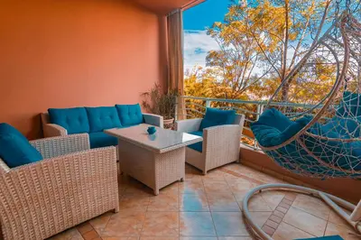 a patio with chairs and a hammock on a balcony at Marrakech Garden Tropical Escape in Marrakech