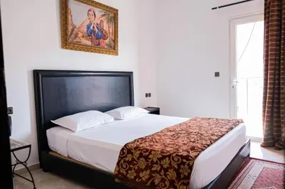 a bedroom with a bed and a picture on the wall at Hotel Apart HLB in Marrakech