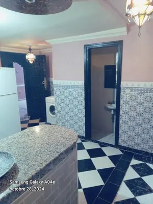 a kitchen with a counter and a checkerboard floor at Riad with swimming pool in Marrakech