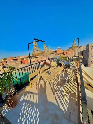 a patio with benches and a view of a city at Riad privé luxe 3 chambres dans la médina de Marrakech y compris petit dejeuner in Marrakech