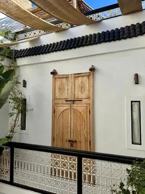 a wooden door on the side of a house at Riad privé luxe 3 chambres dans la médina de Marrakech y compris petit dejeuner in Marrakech