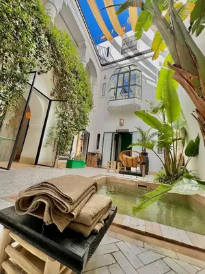 a room with a pool of water in a building at Riad privé luxe 3 chambres dans la médina de Marrakech y compris petit dejeuner in Marrakech