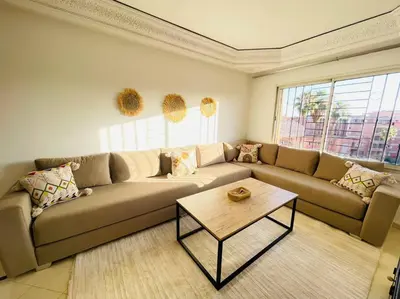 a living room with a couch and a coffee table at Cosy Appartement Centre Gueliz avec piscine in Marrakech