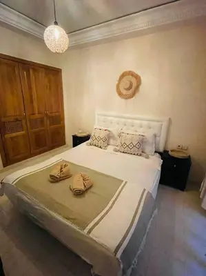 a bedroom with a bed with two slippers on it at Cosy Appartement Centre Gueliz avec piscine in Marrakech