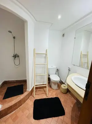 a bathroom with a sink and a toilet and a mirror at Cosy Appartement Centre Gueliz avec piscine in Marrakech