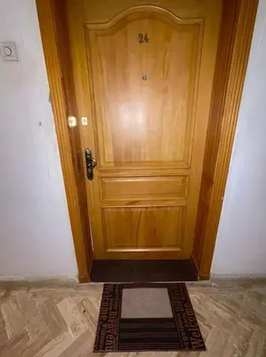 a wooden door with a mat in front of it at Cosy Appartement Centre Gueliz avec piscine in Marrakech