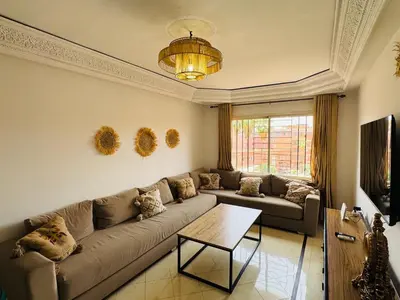 a living room with a couch and a table at Cosy Appartement Centre Gueliz avec piscine in Marrakech