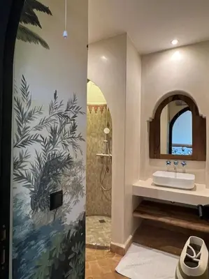 a bathroom with a sink and a shower with a mural at Dar Anacaona in Marrakech