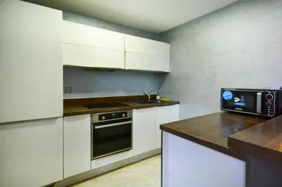 a kitchen with white cabinets and a black oven at Duplexe Luxueux de 2 Suites in Marrakech