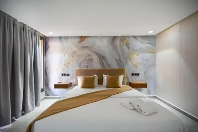 a bedroom with a large bed with a painting on the wall at Duplexe Luxueux de 2 Suites in Marrakech