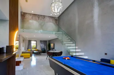 a pool table in a living room with a staircase at Duplexe Luxueux de 2 Suites in Marrakech