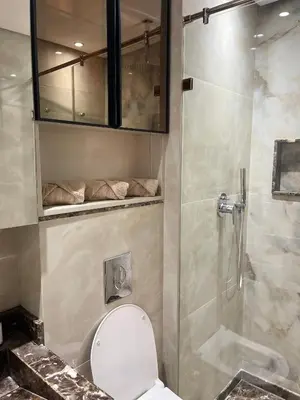 a bathroom with a toilet and a glass shower at Prestigia 2 chambres vue piscine agate in Marrakech