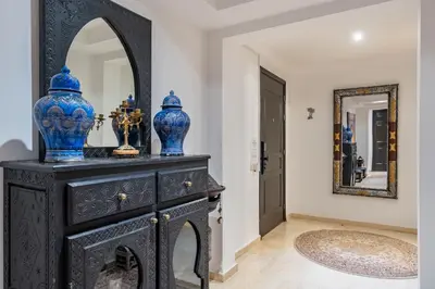 a black dresser with blue vases on it in a hallway at Amazing apartment in the heart of Marrakesh in Marrakech