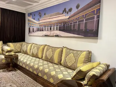 a living room with a couch and a painting on the wall at Amazing apartment in the heart of Marrakesh in Marrakech
