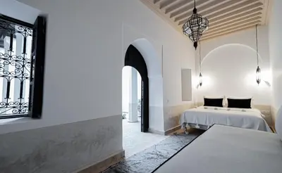 a bedroom with two beds and a window at Riad COPAH in Marrakech