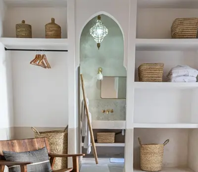 a hallway with a stairway with chairs and a mirror at Riad COPAH in Marrakech