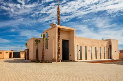a building with a palm tree in front of it at Villa Palmeraie 4 suites zéro vis à vis in Marrakech