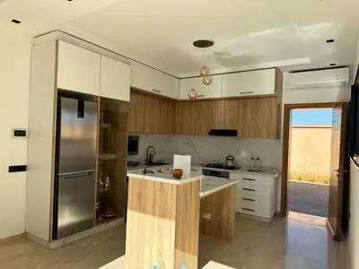 a kitchen with white cabinets and a stainless steel refrigerator at Villa Palmeraie 4 suites zéro vis à vis in Marrakech