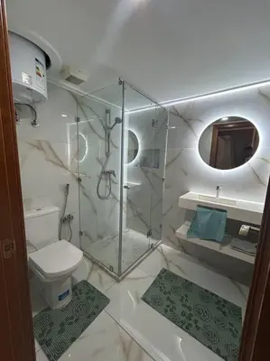 a bathroom with a glass shower and a toilet at Ruime 2 kamer appartement 5 min van het centrum in Marrakech