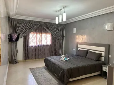 a bedroom with a large bed and a window at Ruime 2 kamer appartement 5 min van het centrum in Marrakech