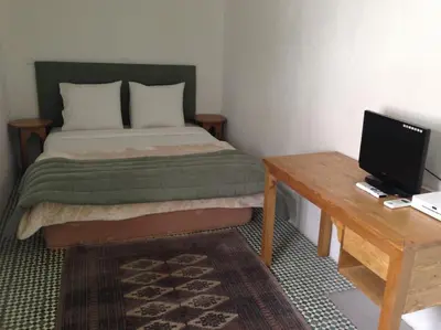 a bedroom with a bed and a desk with a computer at Riad Charij in Marrakech